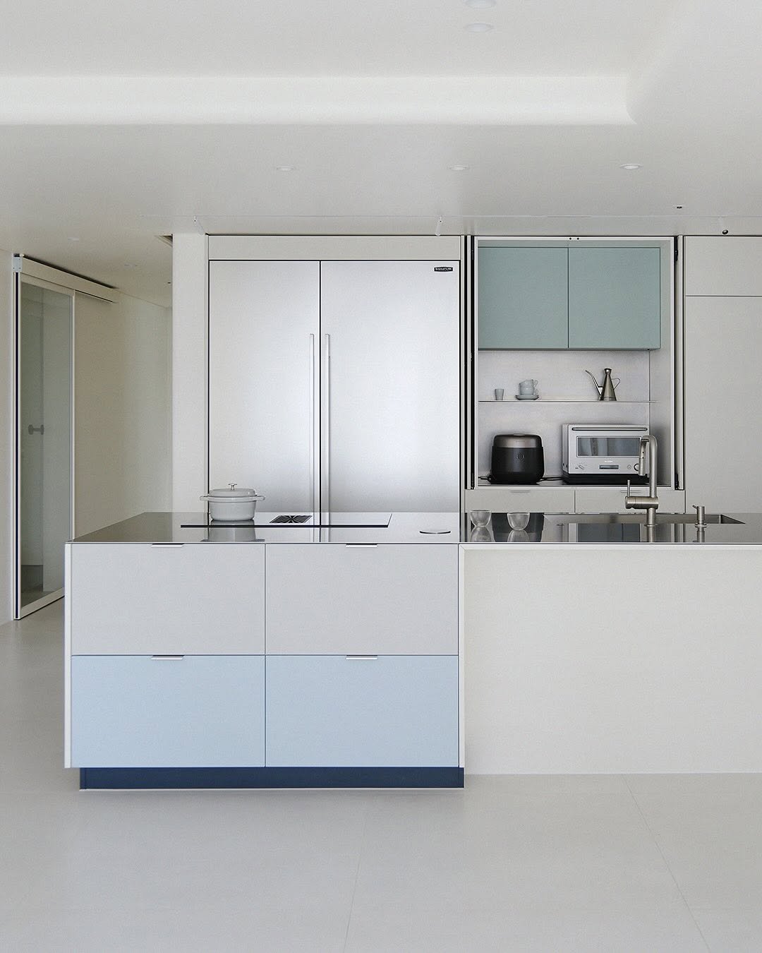 Photo by MMK_community on September 30, 2025. May be an image of kitchen island, lighting, refrigerator, cabinet, indoors, sliding door, kitchen and text.