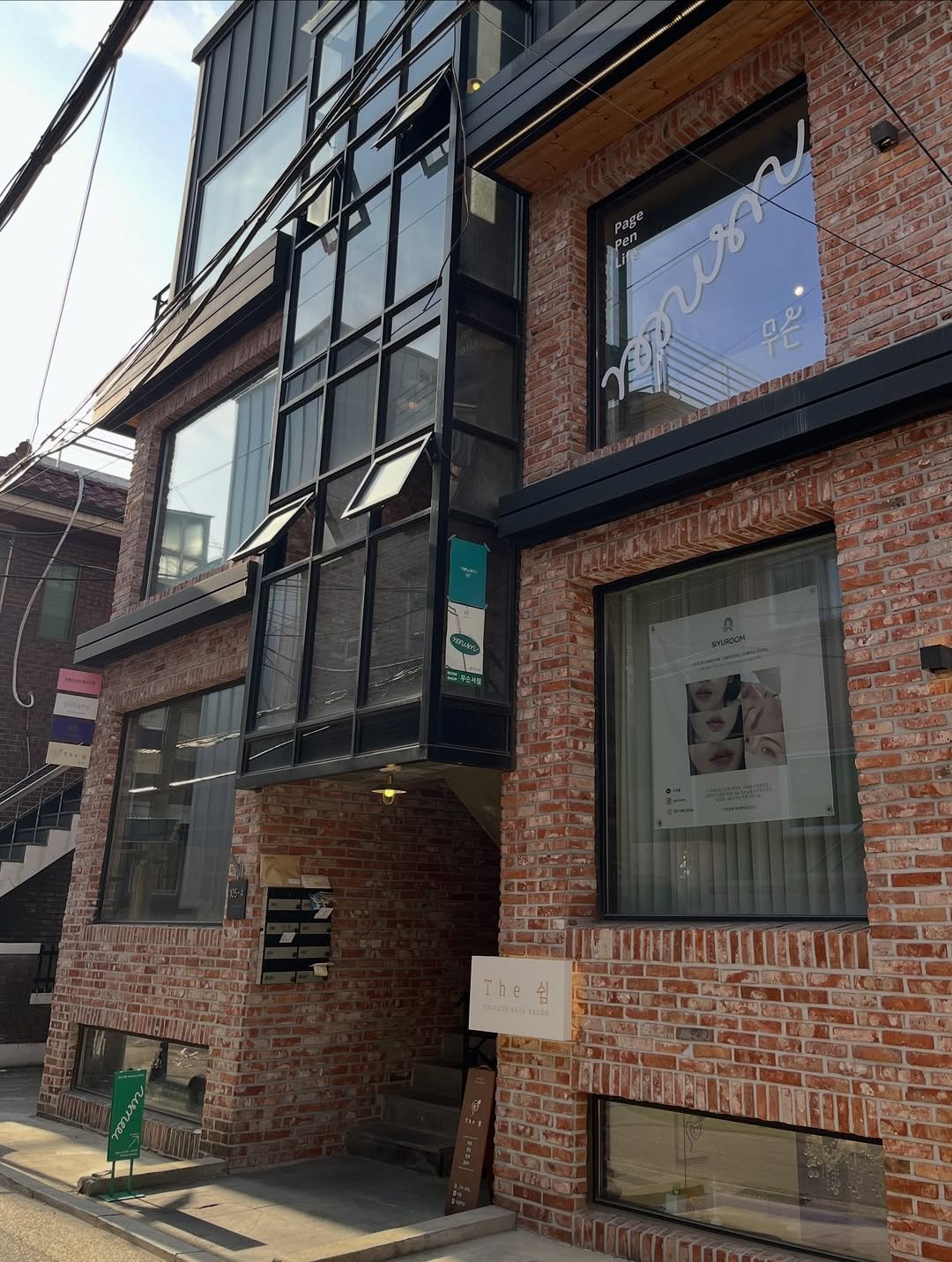 Photo by 무슨서점 | 연남동서점 on April 24, 2026. May be an image of display case, window, brick wall, buildings and text.
