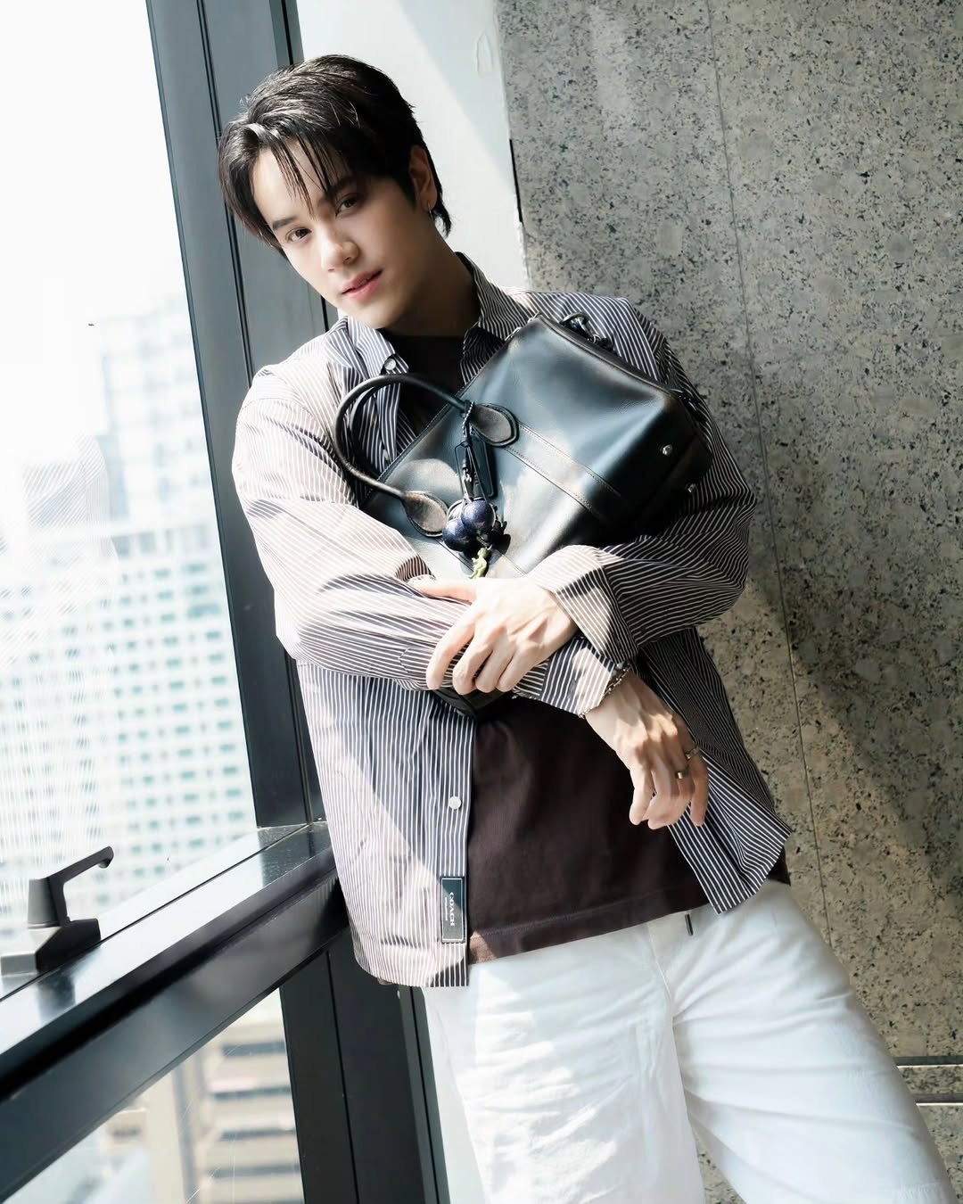 Photo shared by NANON on April 25, 2026 tagging @coach. May be an image of one or more people, hair, bolo tie, blazer, top and text.