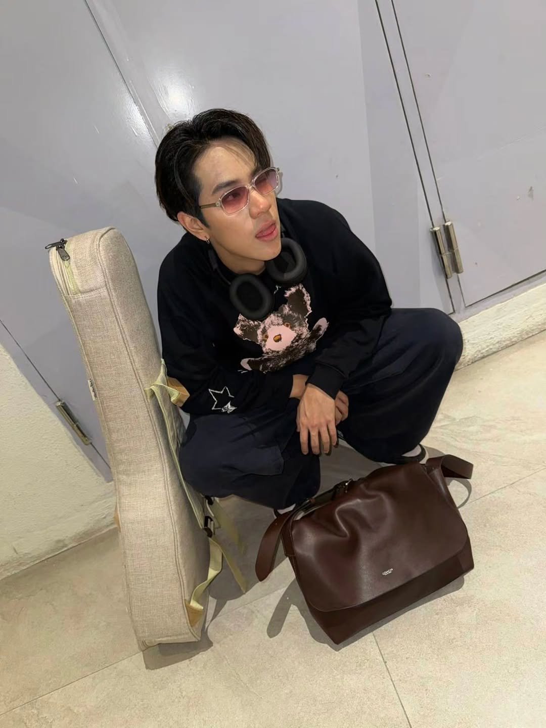 Photo shared by NANON on December 01, 2025 tagging @coach. May be an image of duffle coat, wingtip shoes, sweatpants, briefcase and text.