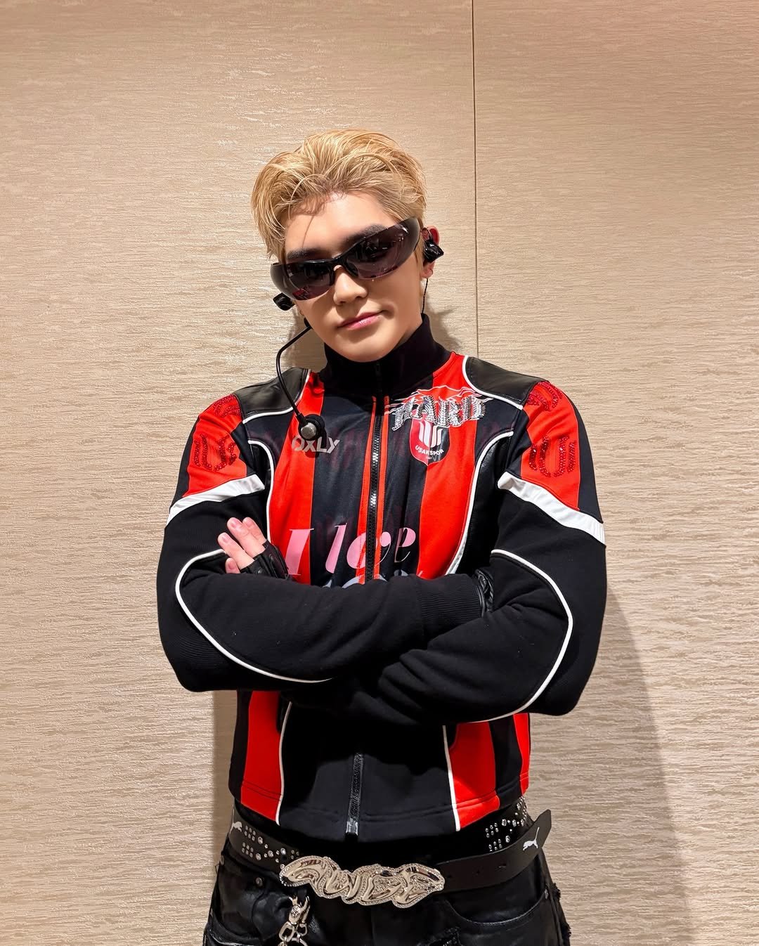 Photo shared by NCT Official Instagram on February 16, 2026 tagging @taeoxo_nct. May be an image of one or more people, blonde hair, people racing vehicles, helmet, glasses and text.