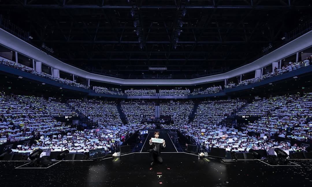 Photo shared by NCT Official Instagram on August 16, 2025 tagging @do0_nct. May be an image of 1 person, crowd, concert, stadium and text.