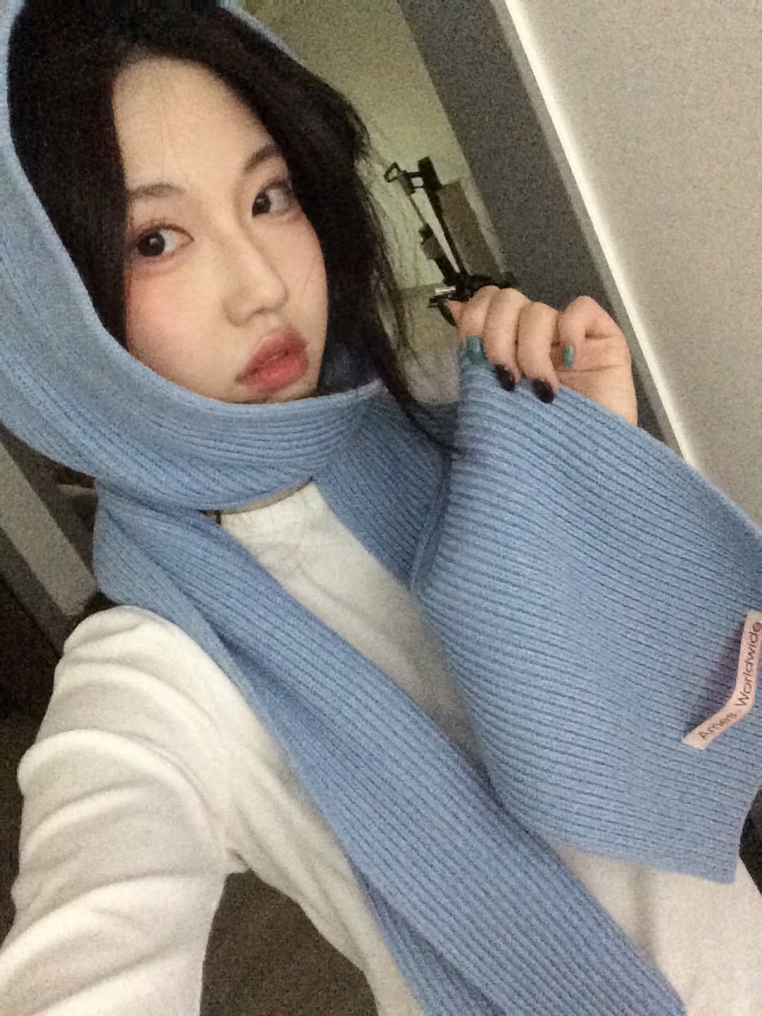 Photo shared by 여진 on January 15, 2026 tagging @ames_worldwide. May be an image of scarf, duffle coat, cloak, turtleneck, parka, face mask, bath robe and text.