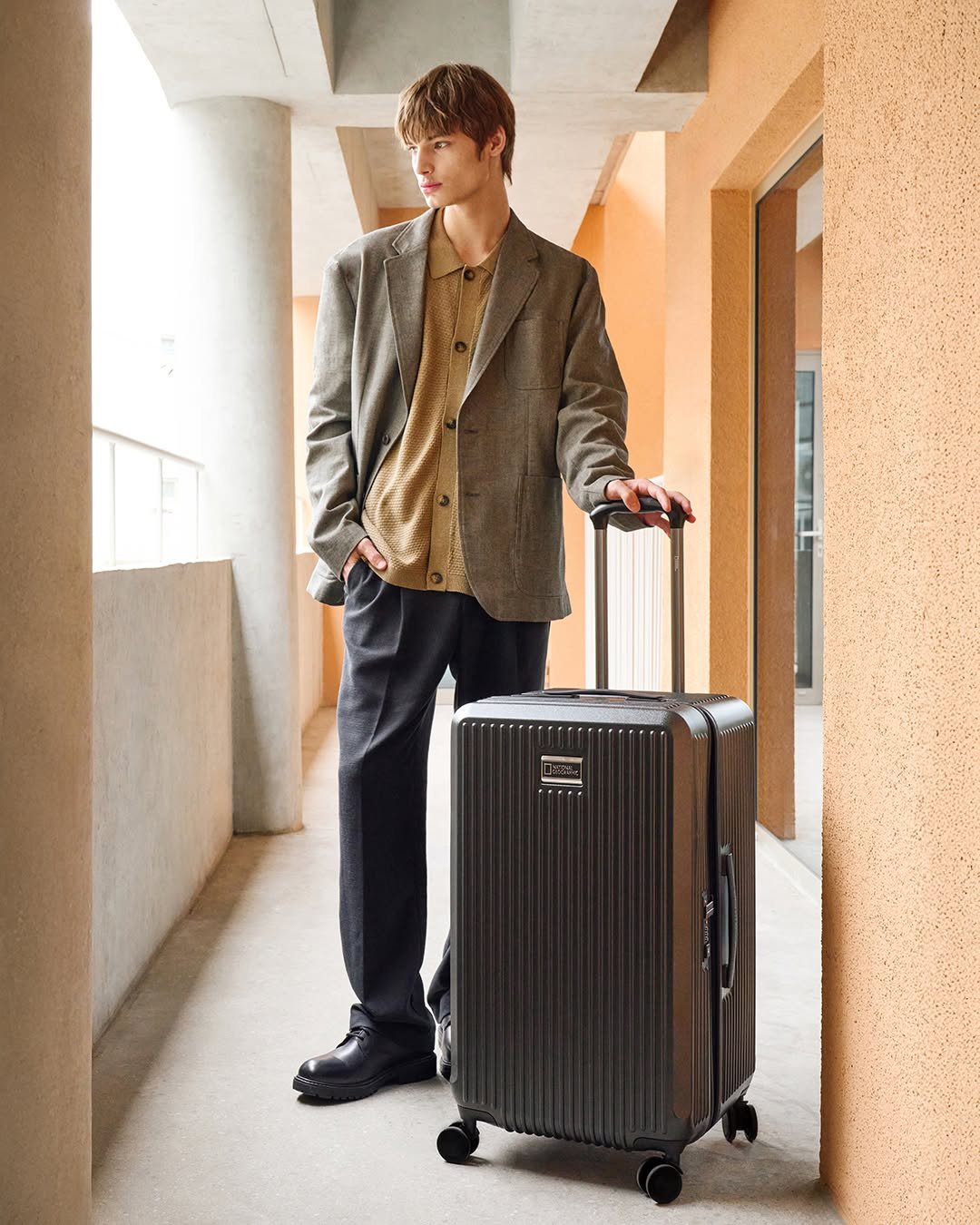 Photo by 내셔널지오그래픽 어패럴 on October 05, 2025. May be an image of 1 person, suitcase, luggage, briefcase and text.
