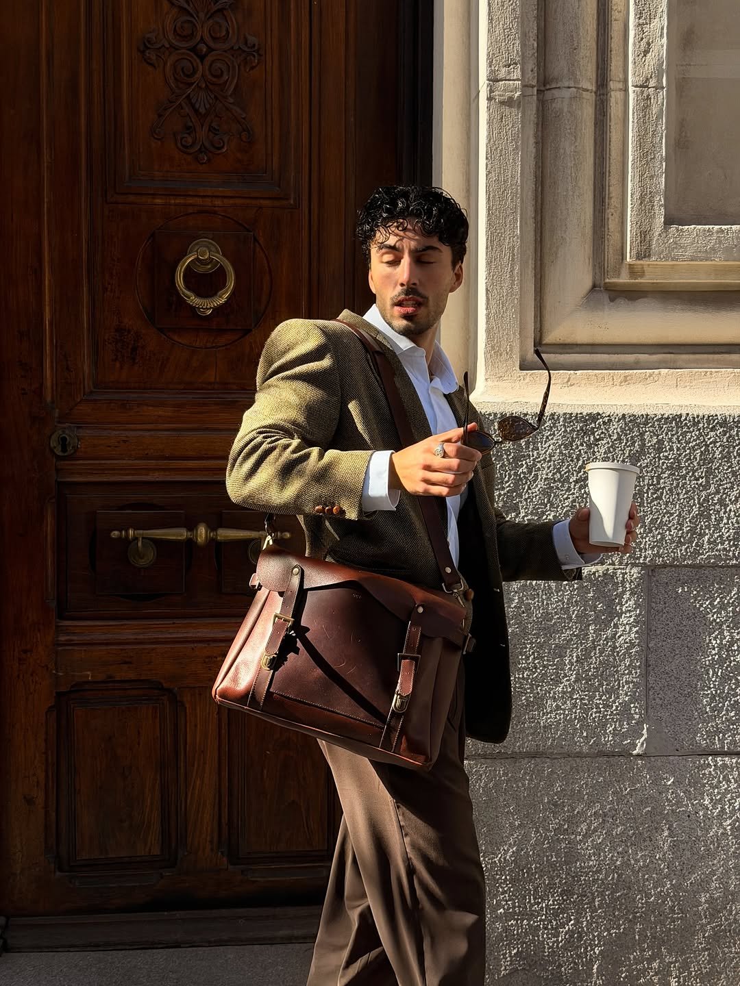 Photo by Nico on November 18, 2025. May be an image of suit, overcoat, purse, briefcase and text.