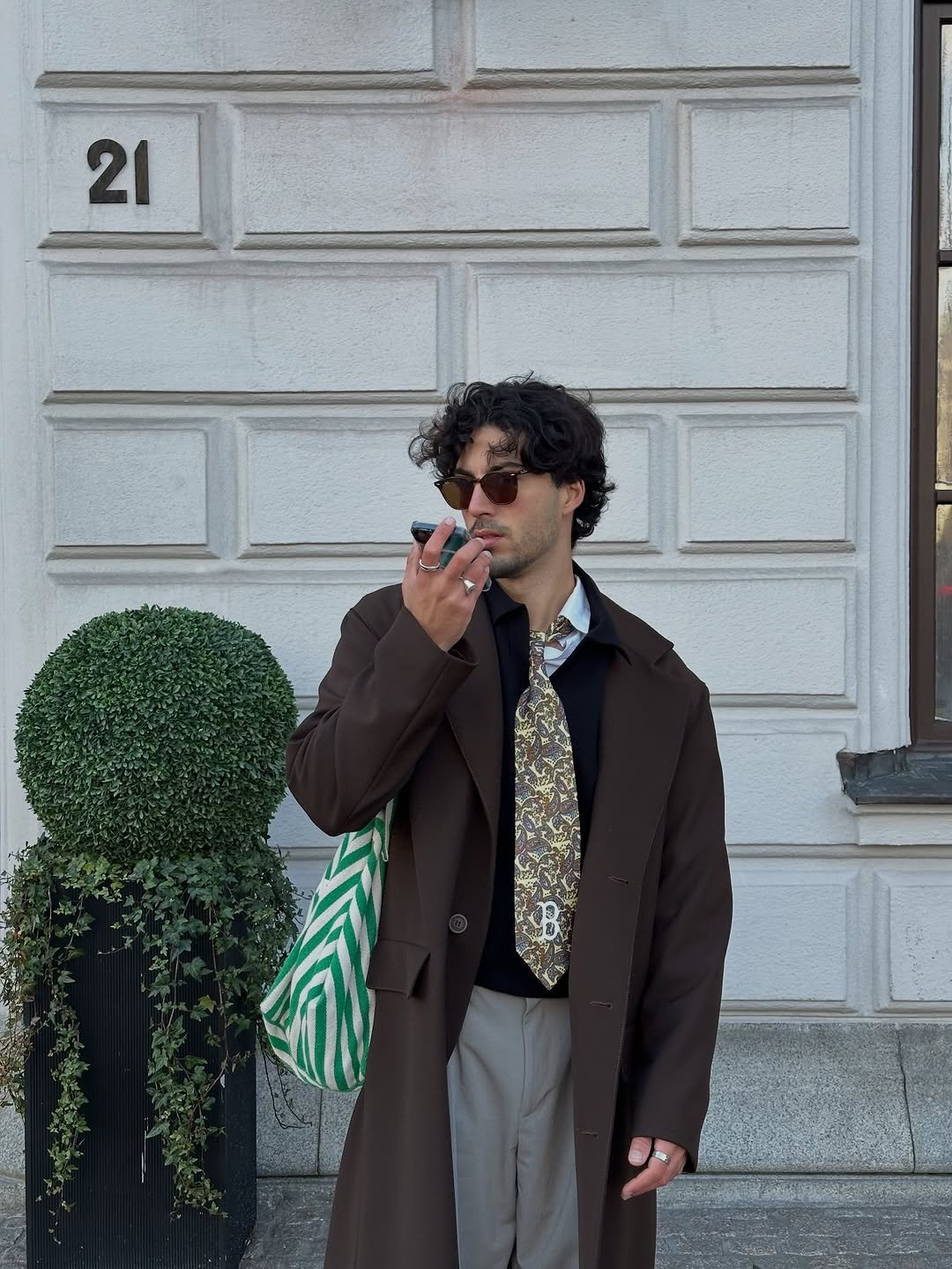 Photo by Nico on November 25, 2025. May be an image of smoking, duffle coat, phone, overcoat, cigarette and text.