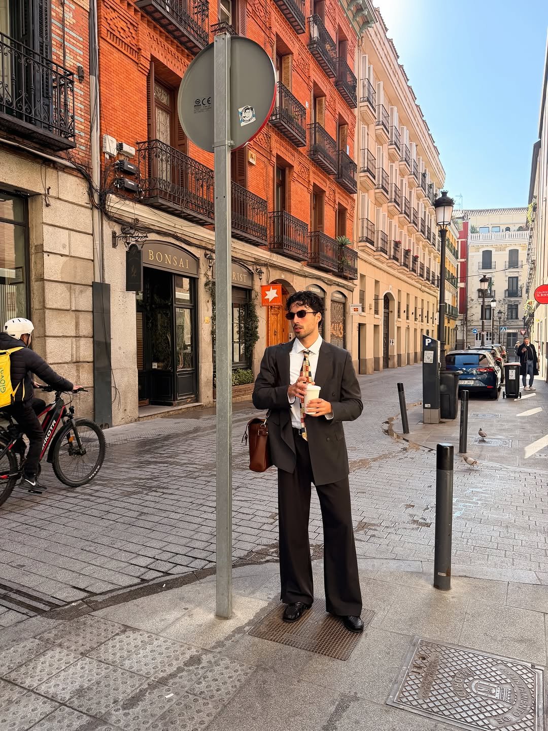 Photo by Nico on November 27, 2025. May be an image of one or more people, overcoat, bowler hat, street and text.