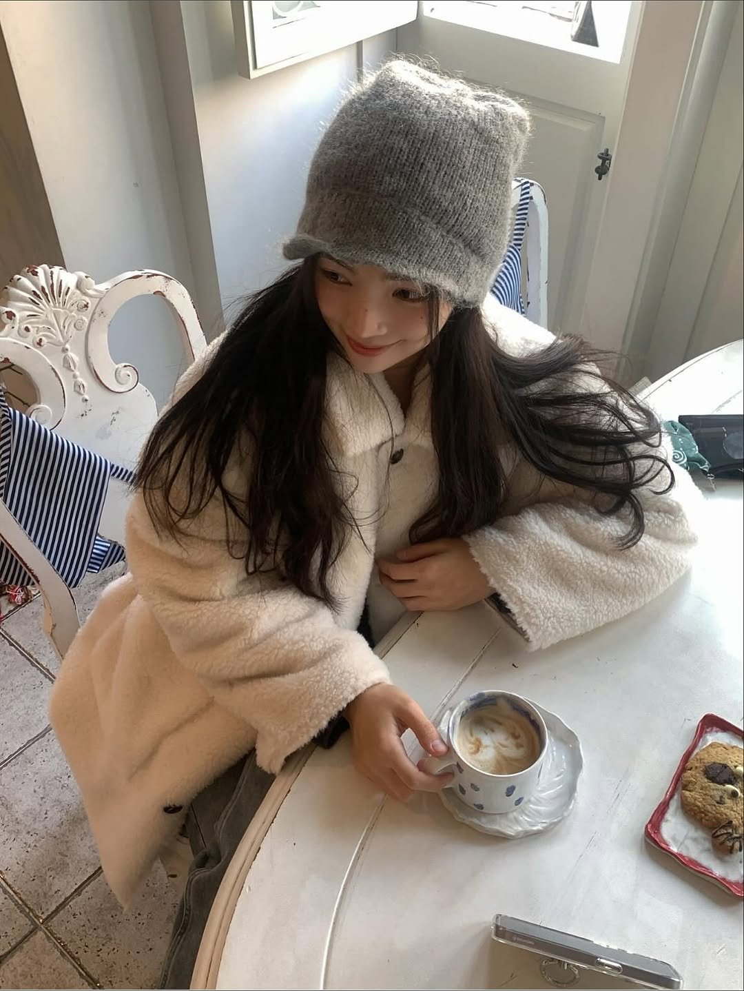 Photo shared by 여울 yeowool on November 17, 2025 tagging @siarohouse, and @thelille_official. May be an image of duffle coat, hat, coffee cup, sleepwear, coffee, parka, bath robe, knit, beret, cornflower and text.