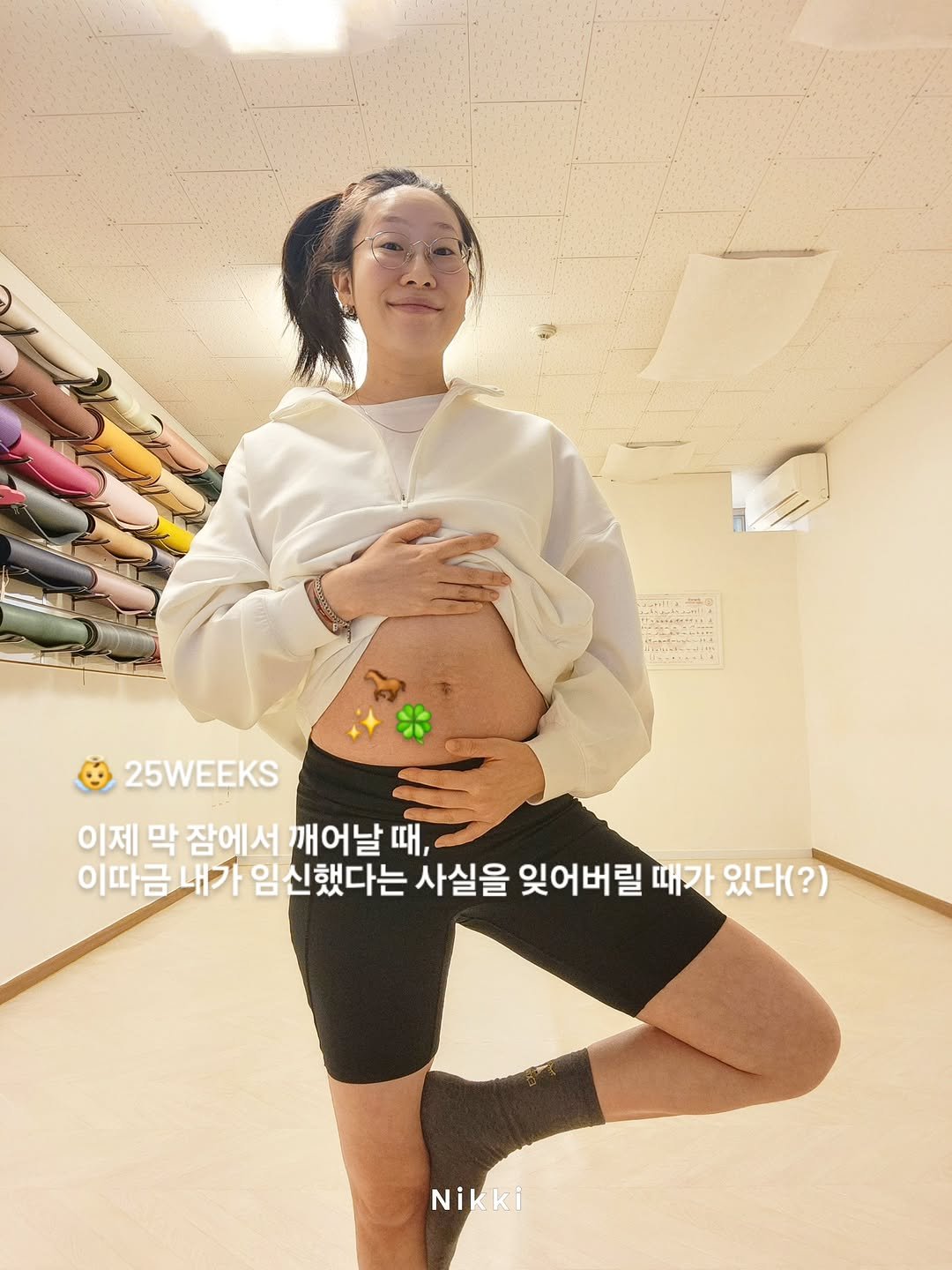 Photo shared by Young Lee_ NIKKI on December 14, 2025 tagging @bradley_hong. May be an image of top, sweatpants, diaper and text that says '25WEEKS 이제 막 잠에서 깨어날 때때, 이따금내가 내가 임신했다는 사실을 잊어버릴 때가 있다(?) Nikki'.