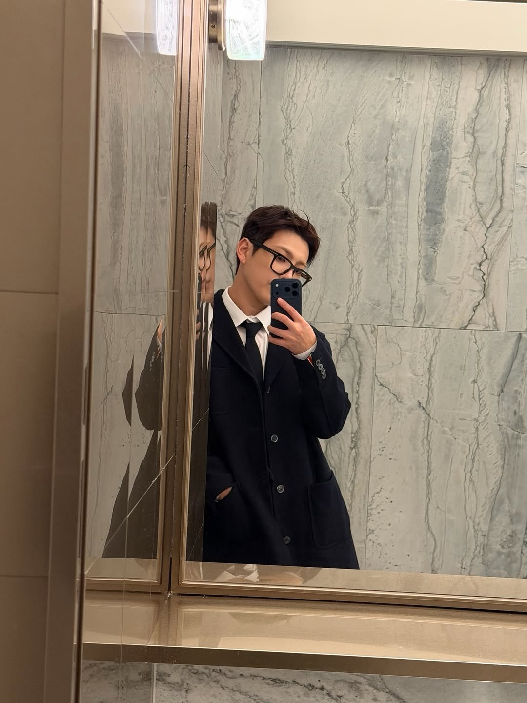 Photo by 홍중 (HONGJOONG) on March 22, 2026. May be a selfie of duffle coat, overcoat, mirror, suit, blazer and text.