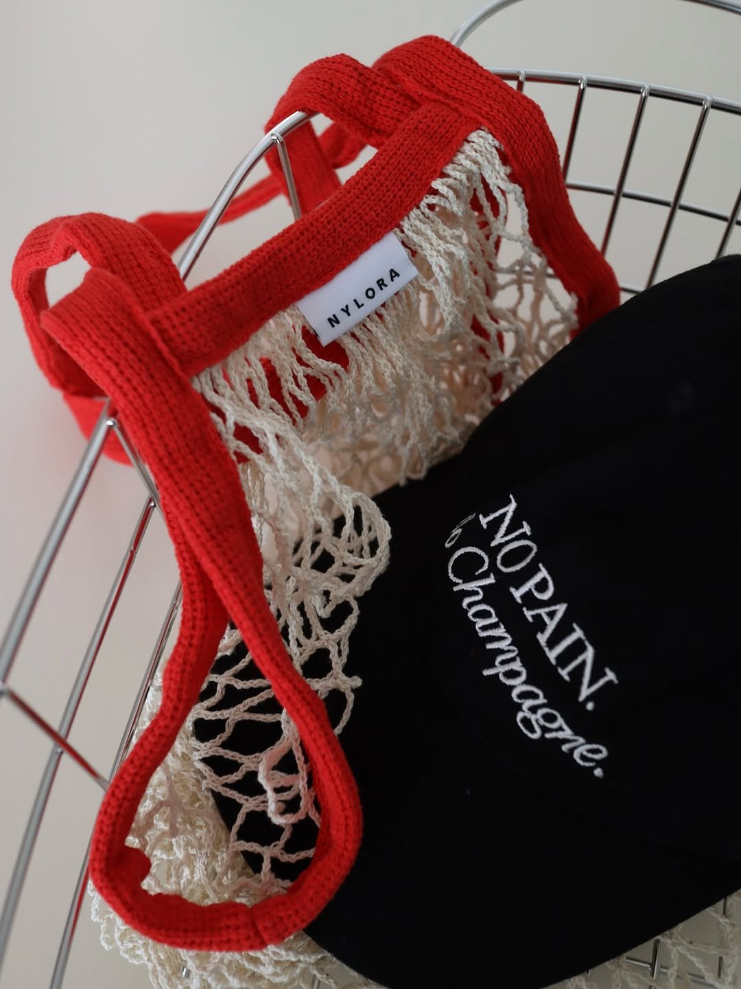 Photo shared by Noella is Brave on November 12, 2025 tagging @nylora_studio, and @nylora_kr. May be an image of macrame, lace, hat, grocery bag, crochet, fishnet stockings and text that says 'NYLORA NYLORA Champagne. MDBIN NOPAIN.'.