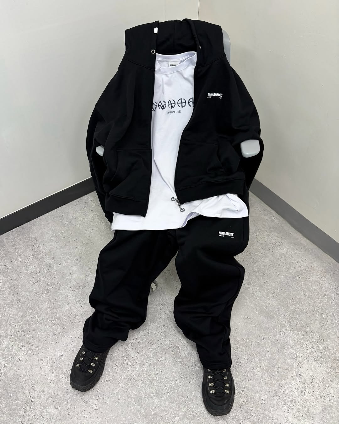Photo by NOMANUAL® on November 24, 2025. May be an image of goosedown coat, snowsuit, jacket, sweatpants, raincoat, parka, sweatsuit, sportswear, fleece and text.
