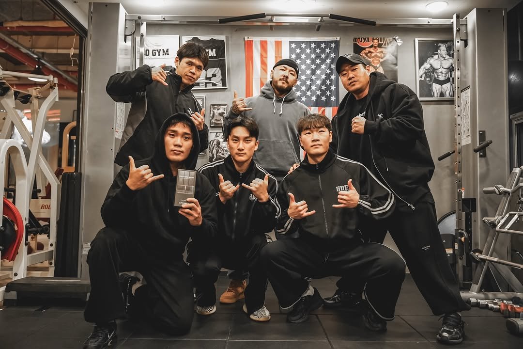 Photo shared by 오지는 오짐의 오관장 on January 24, 2026 tagging @_jsh1393, @korea_mecca_ogym, @cureshield_official, @go_gun_ho, @hyunjinnn.kim, @j.__ack, and @_rlatmdwnss. May be an image of one or more people, people bodybuilding, punching bag, barbell, sportswear and text that says 'DGYM 0 GYM M LM 山 BOL HDE 取'.