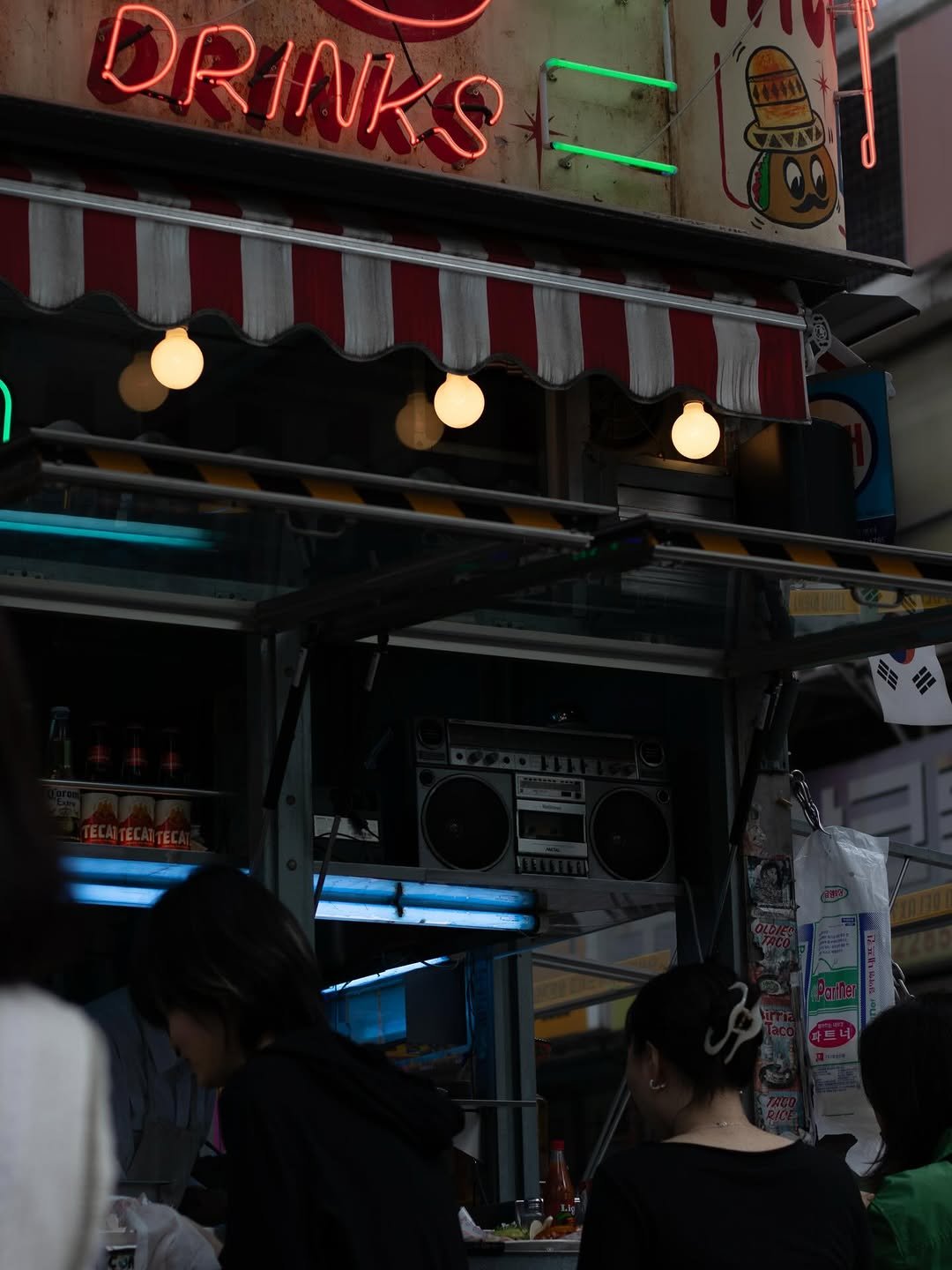 Photo shared by Renan Marie on January 29, 2026 tagging @canonfrance, @canonkorea, @canondeutschland, @oldieshouse, and @oldiestaco. May be an image of one or more people, signboard, street and text that says 'DRINK I'.