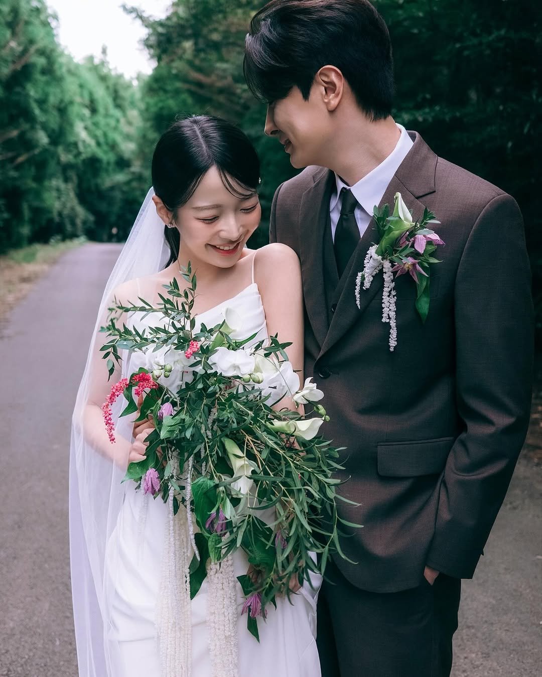 Photo shared by 온리그래퍼 신익수/ 제주스냅 서울스냅 웨딩스냅 커플스냅 on October 28, 2025 tagging @paikbon, @ramong_pic_, @la_vie_en_rose_jeju, @soyoniyaa, @by_moon_official, @poodlecouple, @by_moon_dress, @browntail_jeju_suit, @hwangom_film, and @only.grapher_wedding. May be an image of one or more people, bouquet, prairie gentian, amaranth, baby's-breath, wedding, outdoors and text.