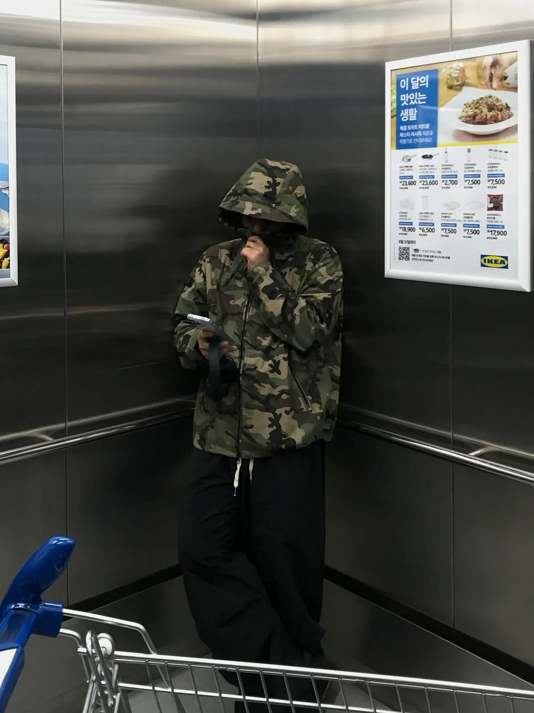 Photo shared by 오윤택/오태기 on September 29, 2025 tagging @ohtaeki_official. May be an image of 1 person, duffle coat, face mask, raincoat, parka, military uniform, shopping cart and text.