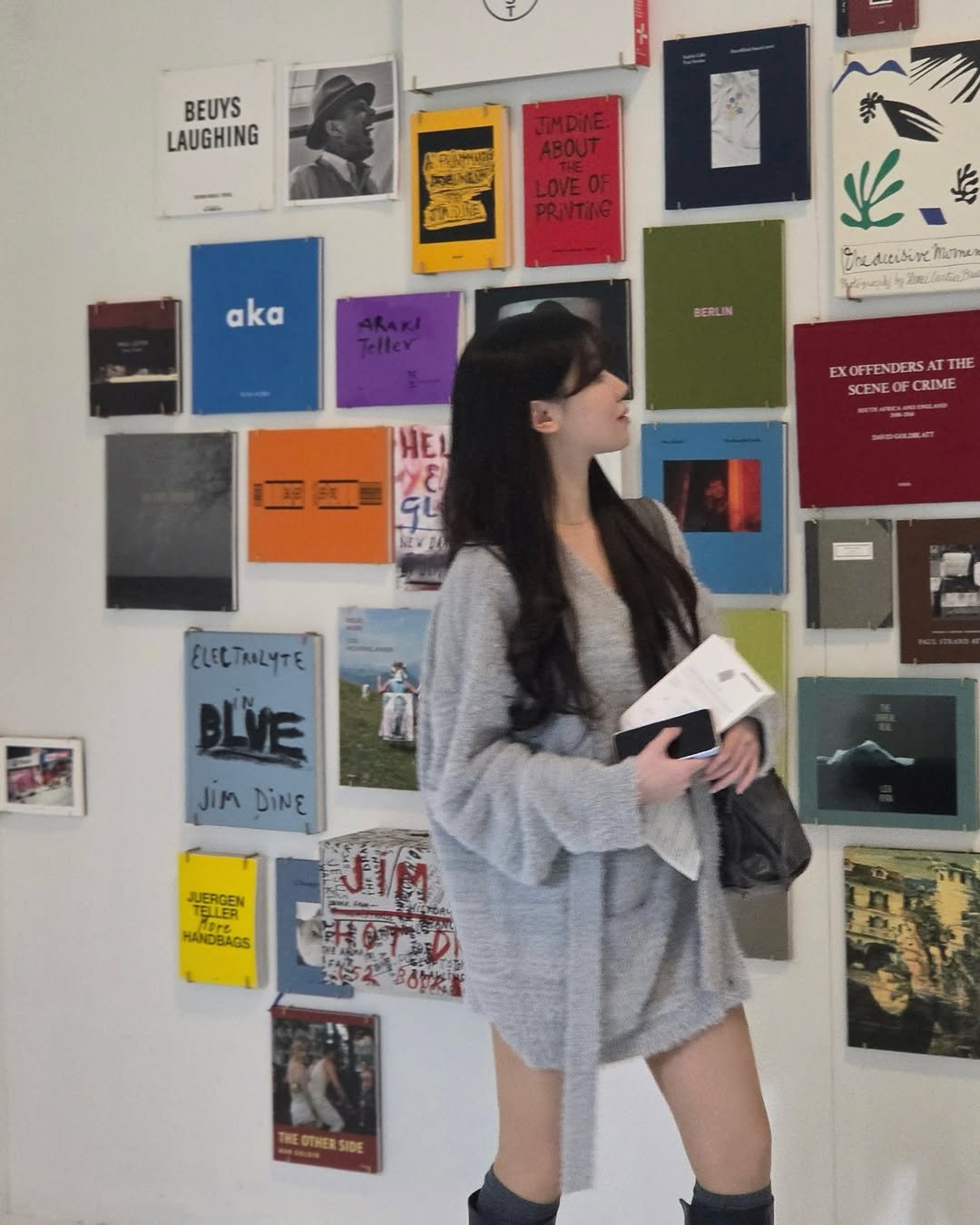 Photo by 밍서 on December 10, 2025. May be an image of standing, overcoat, miniskirt, parka, book, turtleneck, newspaper, poster, cornflower and text.