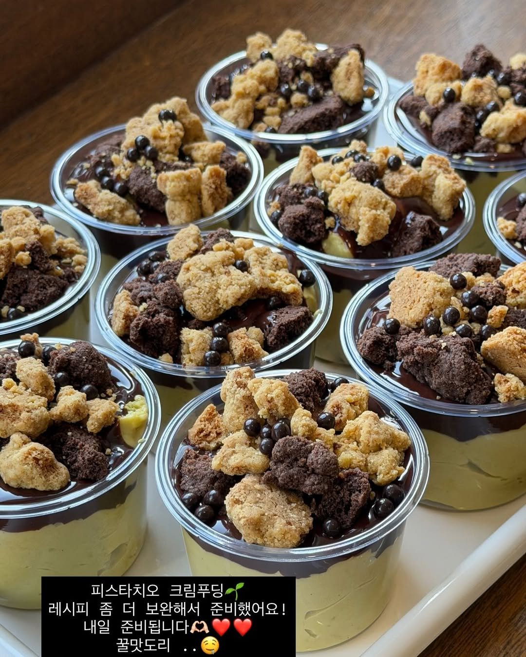 Photo by 단추과자상점 | 청리단길 | 디저트카페 | 다쿠아즈 | 수제디저트 | 두바이쫀득쿠키 on April 18, 2026. May be an image of gelato, cupcake, tiramisu, fudge, chocolate mousse, granola, brownie and text that says 'L 피스타치오 크림푸딩 레시피 좀 더 보완해서 준비 준비했어요! 내일 준비됩니다^ 꿀맛도리'.