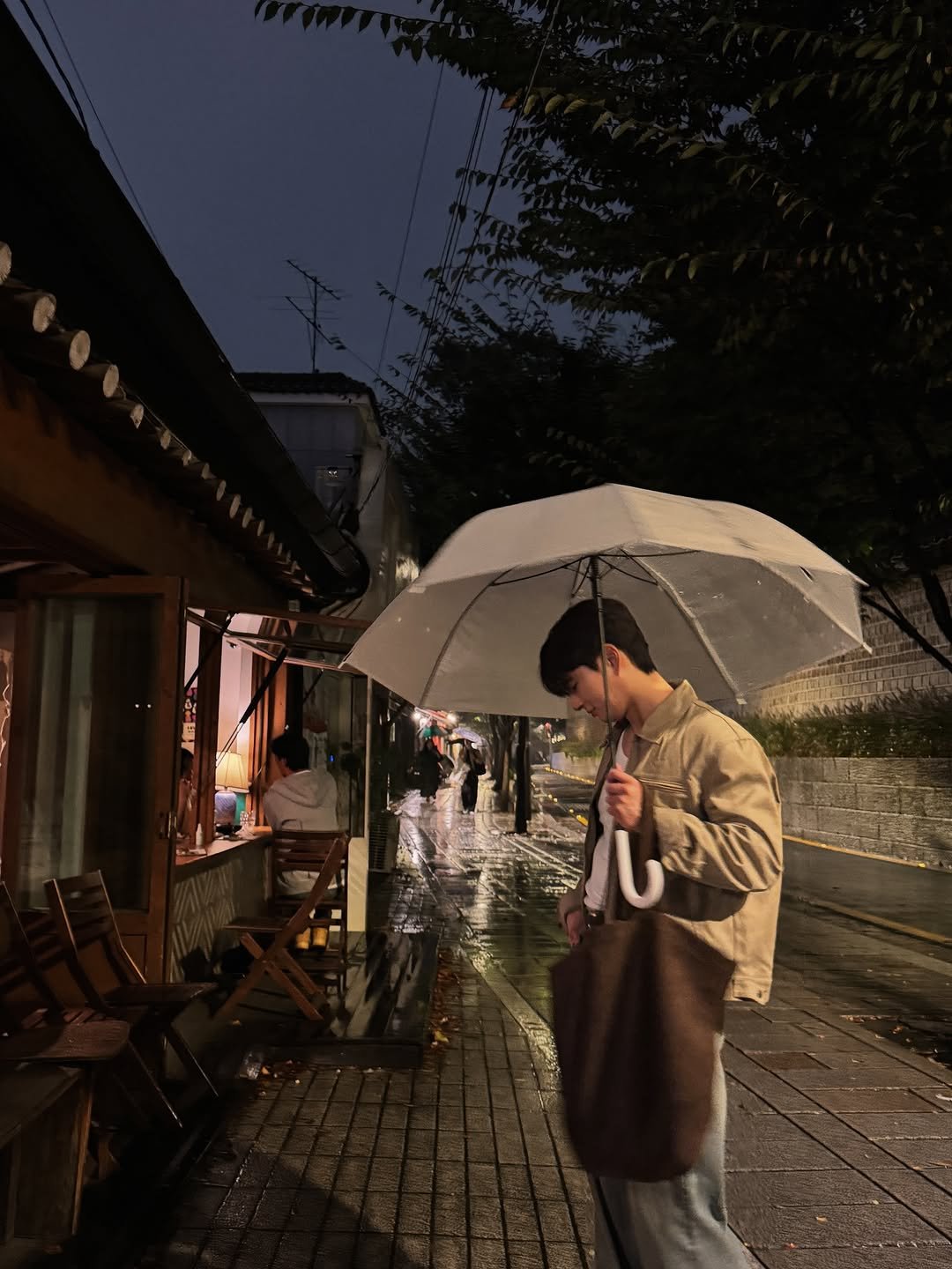 Photo by 박찬영 | Chanyoung Park on October 19, 2025. May be an image of one or more people, duffle coat, wind chime, umbrella, parasol, Fushimi Inari Taisha, street and text.