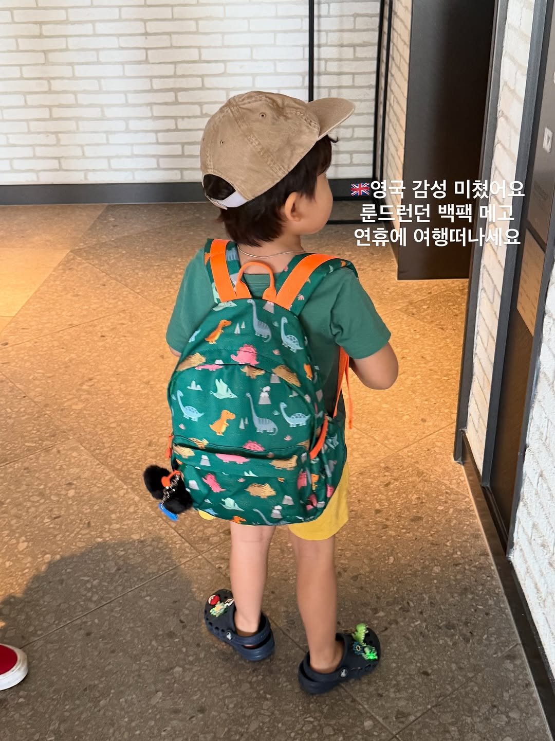 Photo by 최 진희 on September 27, 2025. May be an image of 1 person, child, sling, baby shoes, drawstring and text that says '※영국 감성 미쳤어요 미쳤 룬드런던 백팩 메 메고 연휴에 여행떠나세요'.