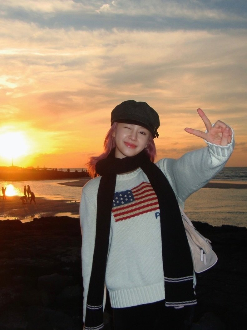 Photo shared by BABYMONSTER PHARITA 파리타 FANPAGE on February 07, 2026 tagging @babymonster_ygs. May be an image of duffle coat, top, parka, turtleneck, beret, beach, ocean and text.