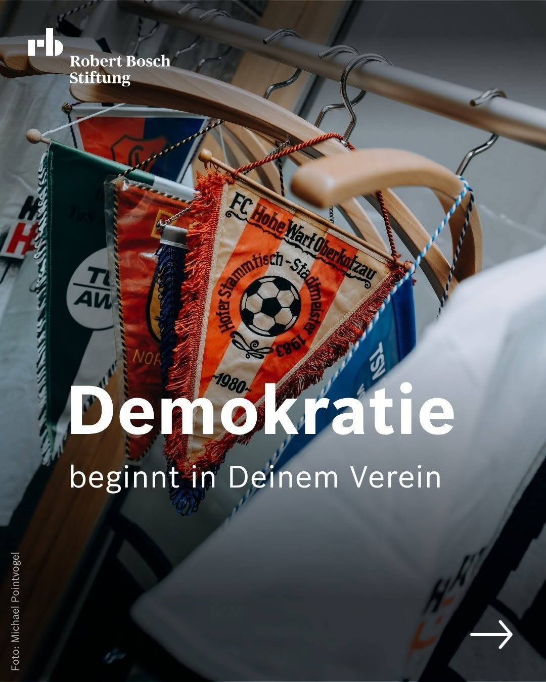 Foto: Vereinswimpel hängen an Kleiderbügeln. Text: "Demokratie beginnt in Deinem Verein"