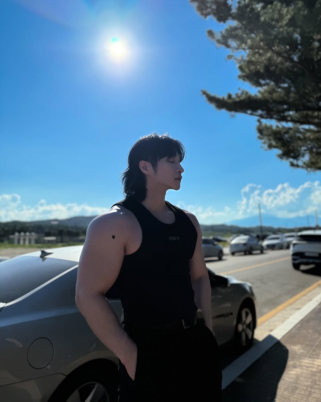 Photo shared by 조준 (Jun Cho) on July 28, 2025 tagging @hdex__official. May be an image of 1 person, biceps, body building, tanktop, road and text.