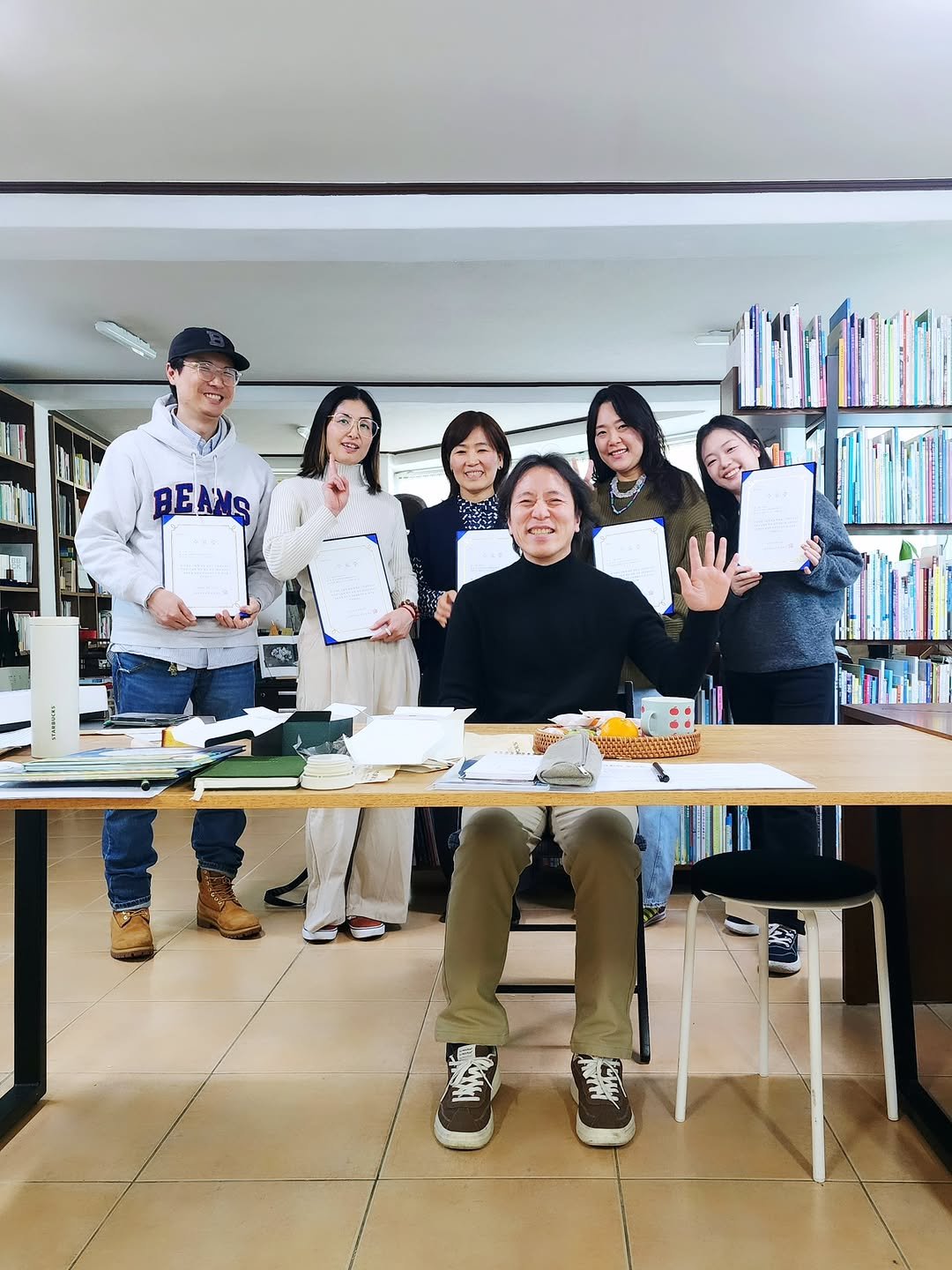 Photo shared by 그림책공작소 on February 20, 2026 tagging @chochung7, @sunmikimkim, @early_latter, @artist__ayaka, @picturebook_gongjackso, and @sido.pak. May be an image of one or more people, people studying, people standing, office and text that says 'BEANS'.