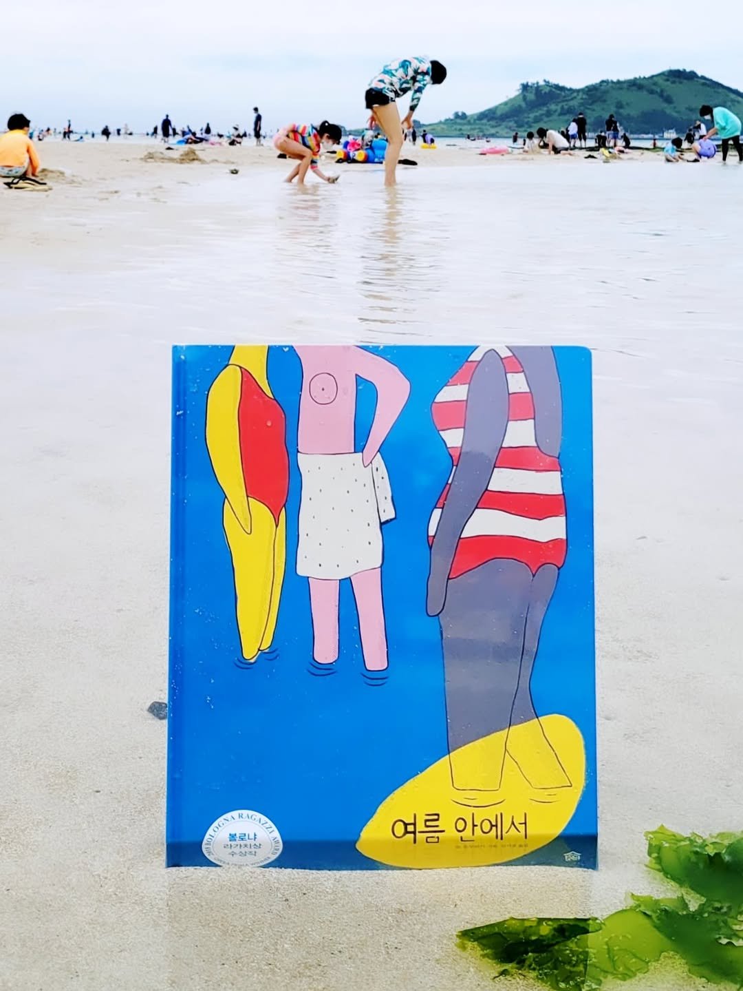 Photo shared by 그림책공작소 on August 09, 2025 tagging @mujer_gallina, @picturebook_gongjackso, @lagrumeeditions, and @inae_sujung. May be an illustration of 8 people, surfboard, beach ball, umbrella, poster and text.