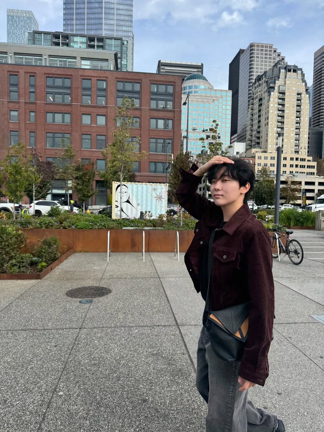 Photo by 승관 SEUNGKWAN on October 10, 2025. May be an image of duffle coat, overcoat, skyscraper and text.