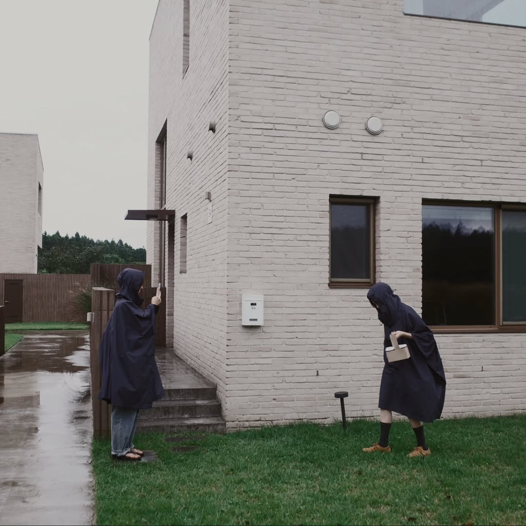 Photo by Plus X on March 31, 2025. May be an image of 2 people, duffle coat, overcoat, raincoat, parka, cloak, umbrella, outdoors and text.