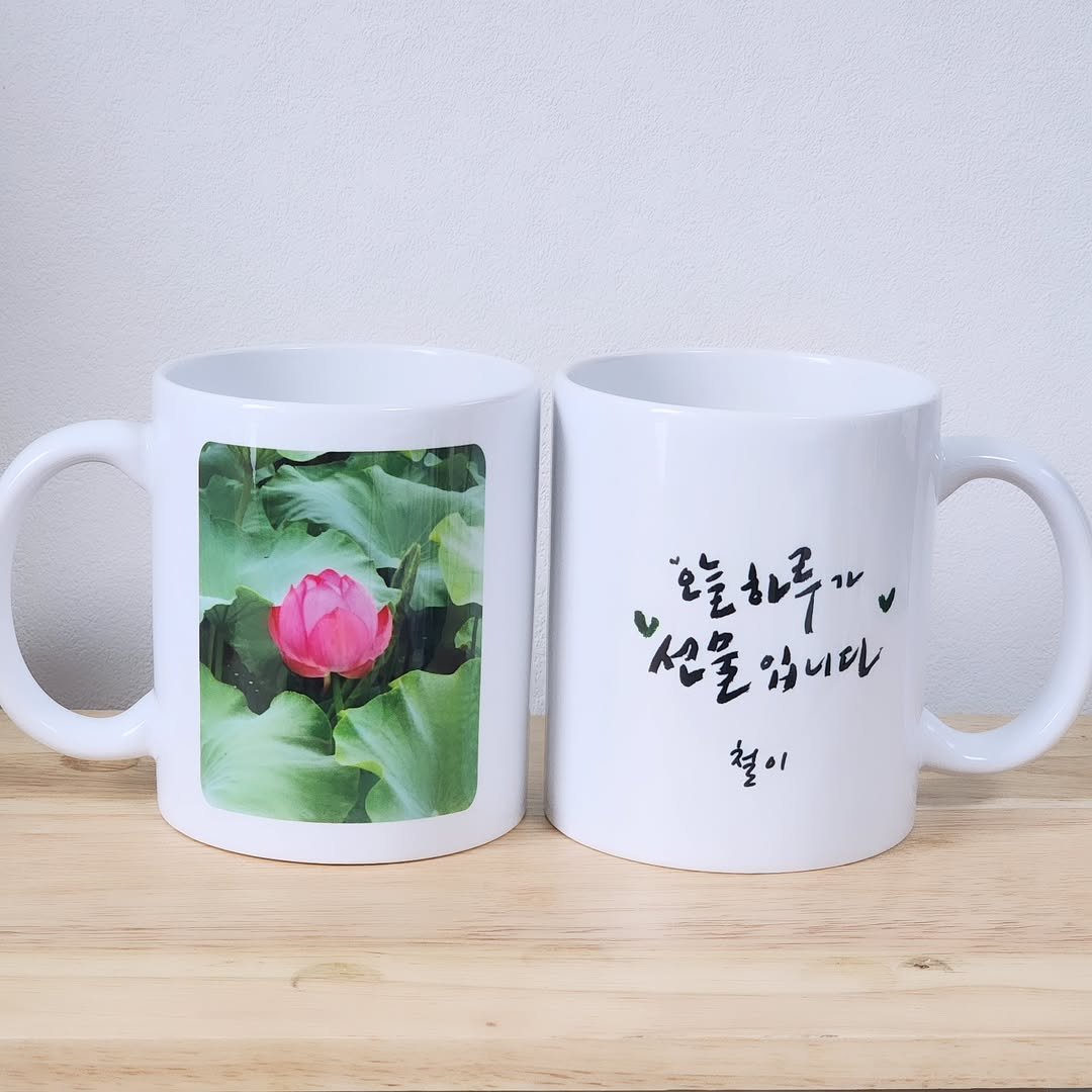 Photo by 퐁실퐁실 선물가게 | 주문제작선물/포토인형 on July 05, 2025. May be an image of coffee cup, kitchenware, cup, teacup, mouse pad, mug and text that says '흔늘하루면 오늘하루 "산물입니다 '씬물 입니다 철이'.