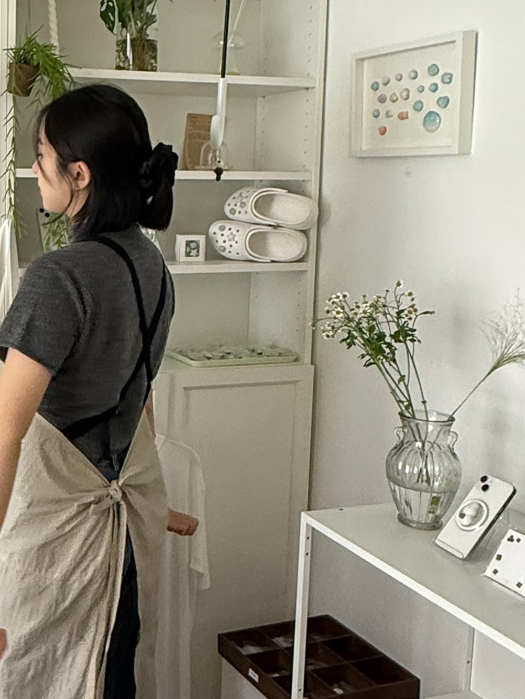 Photo by 푸랴 on October 05, 2025. May be an image of 1 person, apron, pot, pottery, coffee maker and text.