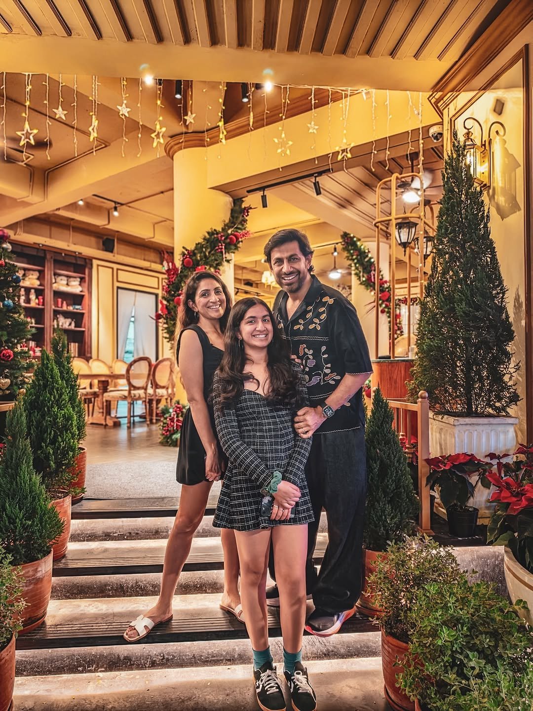 Photo shared by Praveen Bhat Photography on December 25, 2025 tagging @syrabhat, and @bwinstyle. May be an image of one or more people, christmas tree, dress, tinsel and text.