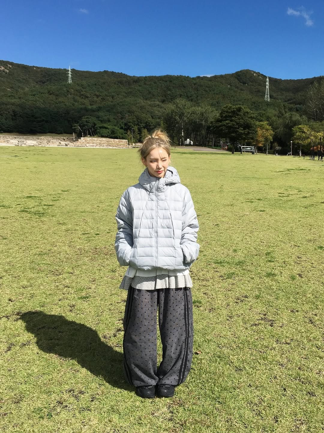 Photo by 안아란 on October 20, 2025. May be an image of goosedown coat, fleece, raincoat, parka, snowsuit, grass, Saqsaywaman, park and text.