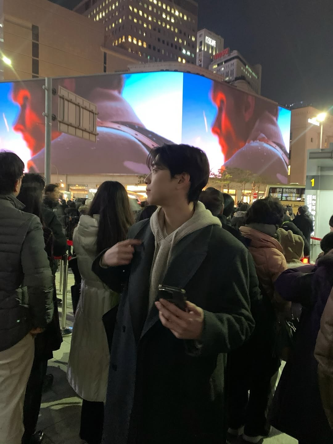 Photo by 데일리 패션 레슬 on December 31, 2025. May be an image of one or more people, people standing, duffle coat, signboard, Times Square and text.