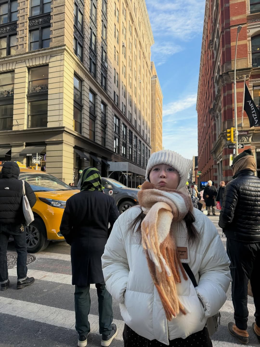 Photo by 리뷰한다 송미니 on February 01, 2026. May be an image of standing, scarf, Times Square and text.