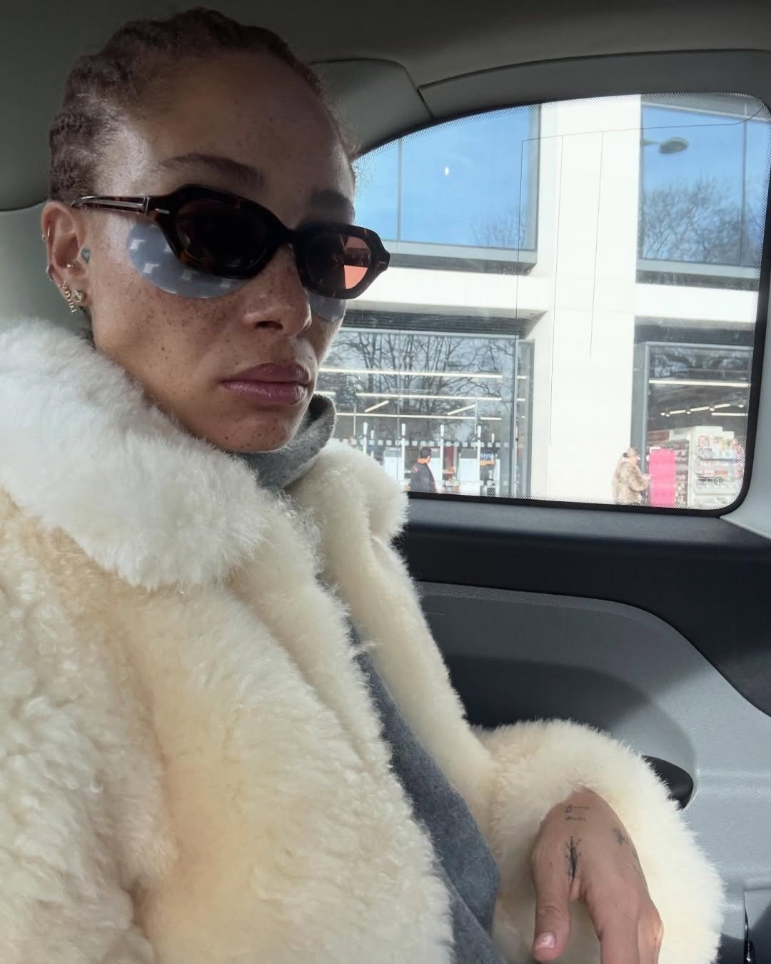 Photo shared by rhode skin on February 27, 2026 tagging @adwoaaboah. May be an image of one or more people, makeup, sable coat, overcoat, eyewear, goosedown coat, parka, jacket and text.