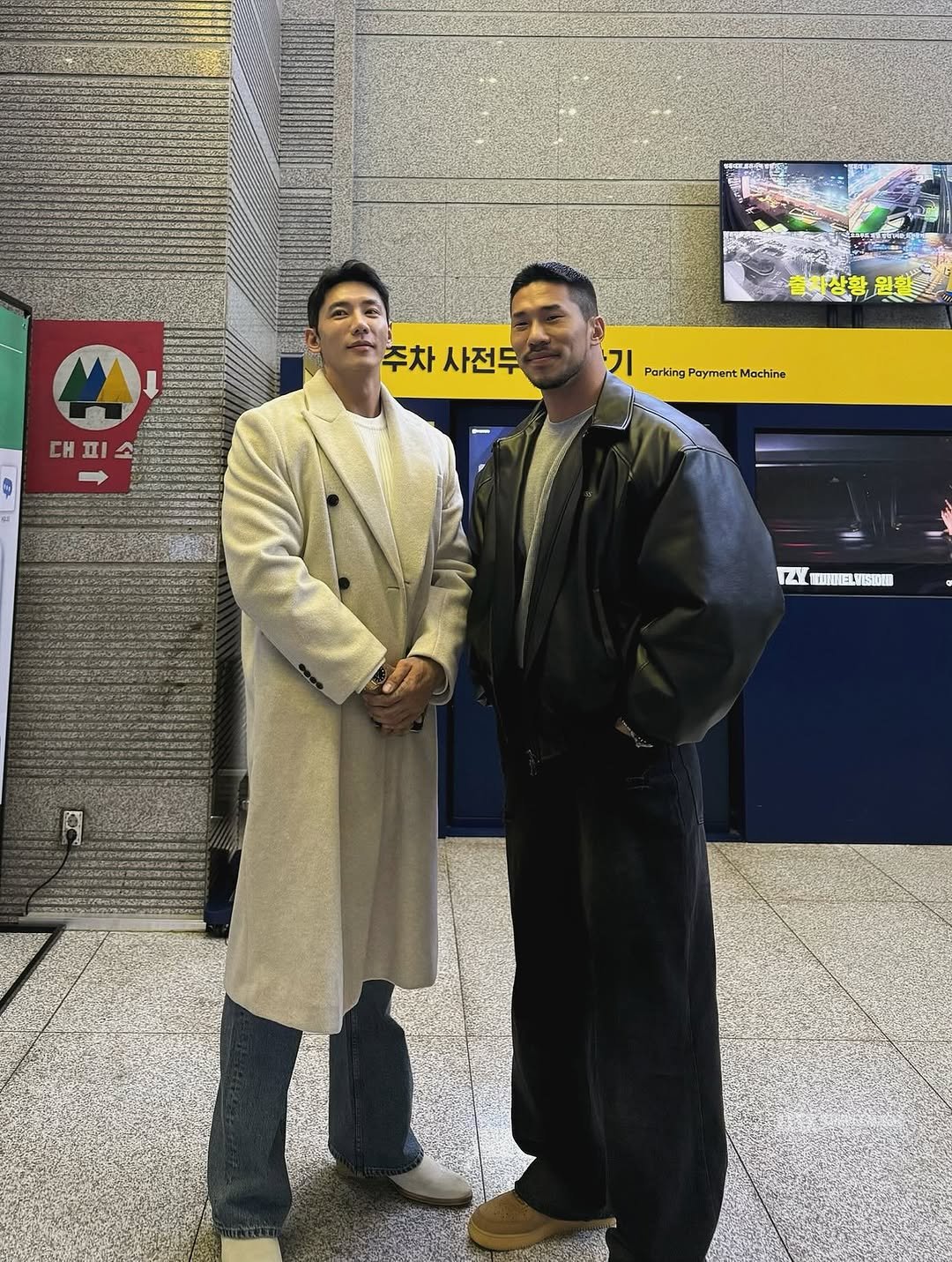 Photo shared by 🇰🇷KUHYUNHO/구현호/ 具贤皓 on November 26, 2025 tagging @ifbbpro_thanos. May be an image of one or more people, people standing, overcoat, duffle coat, jacket, turtleneck, parka and text that says 'A 대피 피 주차 주차사전두 사전두 기 Parldng PartdngPaymentMachine ngPaymentMochine Payment Mochine TAL S10EE'.