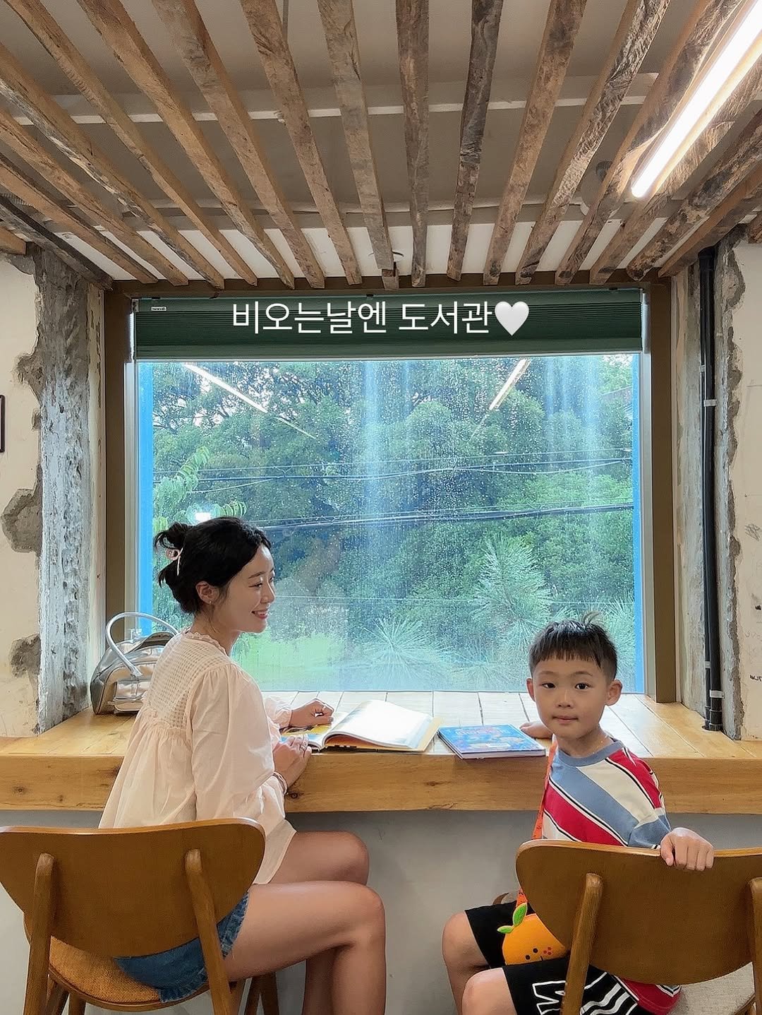 Photo by 김예린 | 린쥬하니 on August 11, 2025. May be an image of 2 people and text that says 'PNAMTNG ចាញា 비오는날엔 도서관'.