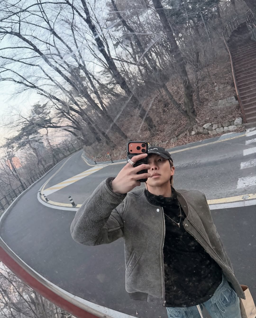 Photo by RM on March 11, 2026. May be a selfie of phone, jacket, mirror, road, park and text.