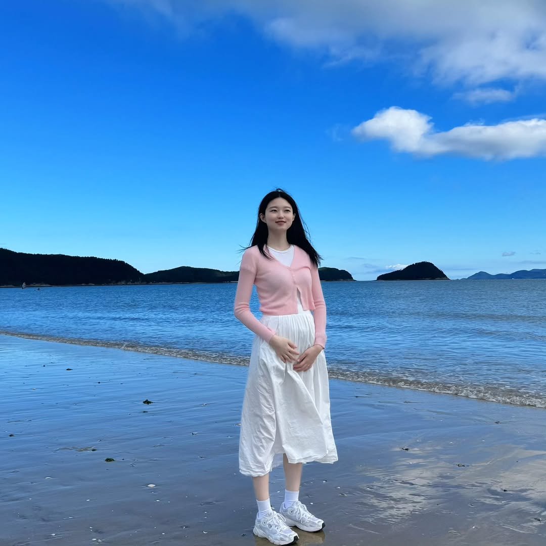 Photo shared by 기아한화커플⚾️ on October 09, 2025 tagging @ddu_bbi. May be an image of 1 person, sundress, beach, ocean, coast and text.