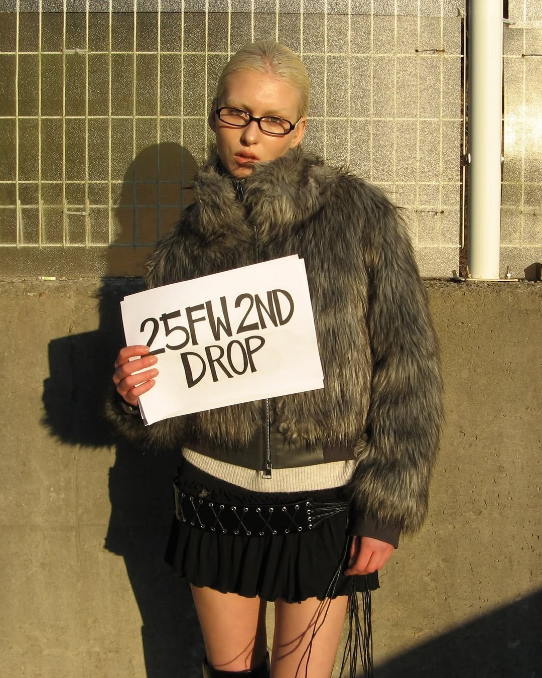 Photo by ROCKCAKE on November 19, 2025. May be an image of one or more people, makeup, fur coat, turtleneck, fishnet stockings, beret, brick wall and text that says 'M'.