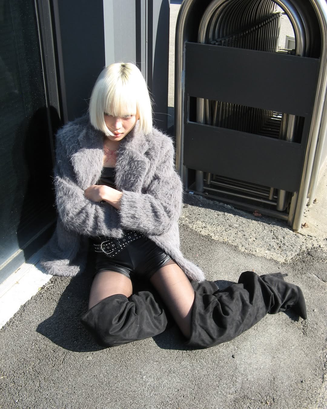 Photo by ROCKCAKE on November 27, 2025. May be an image of one or more people, blonde hair, sable coat, overcoat, fishnet stockings, miniskirt, turtleneck and text.