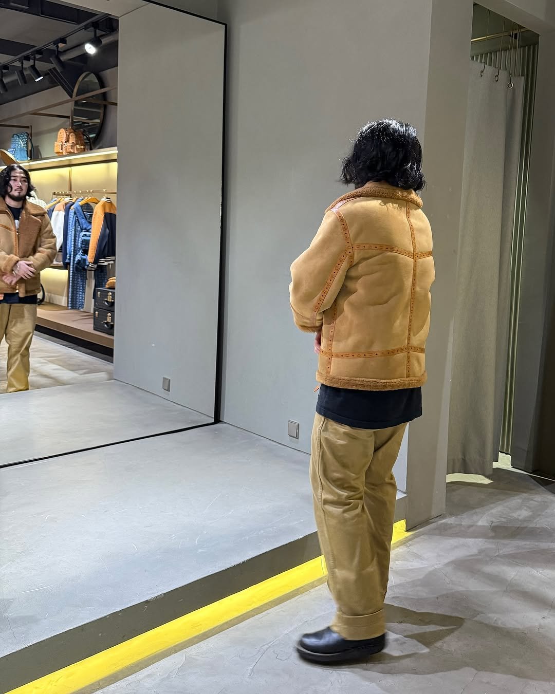 Photo shared by SEONGSU KIM on September 23, 2025 tagging @mcmworldwide. May be an image of 2 people, people standing, duffle coat, overcoat, sable coat, goosedown coat, parka and text.
