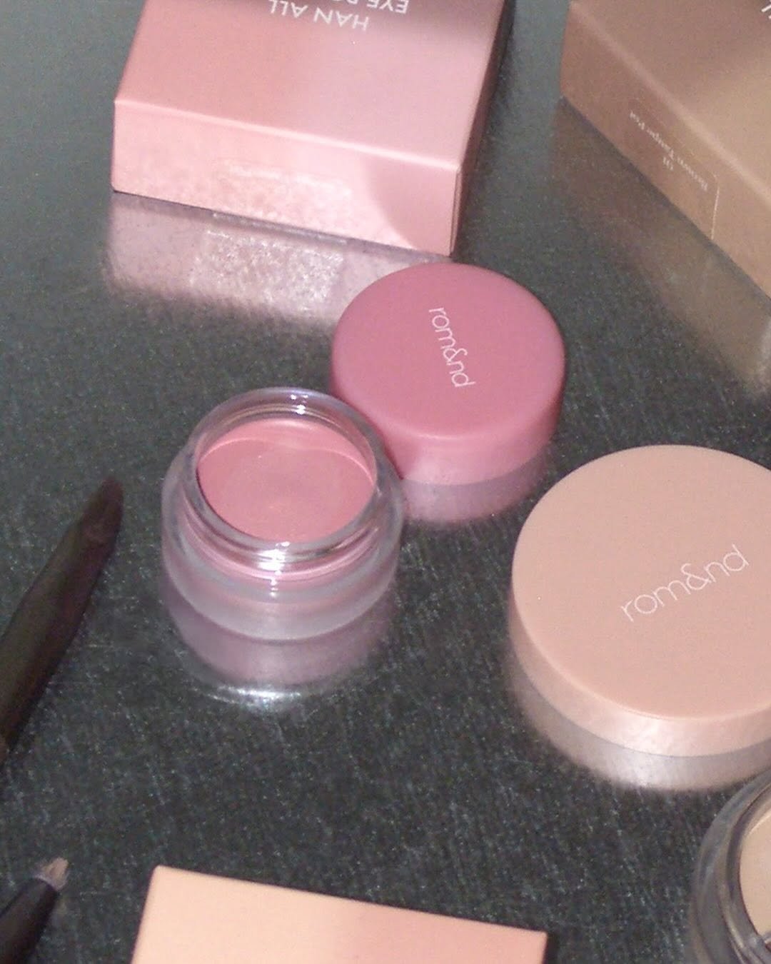 Photo by 롬앤 romand official on October 18, 2025. May be an image of one or more people, makeup, lipstick, pallette, hand cream, cosmetics and text that says 'Y HAN AAAAAH A= romand romend romend romand'.