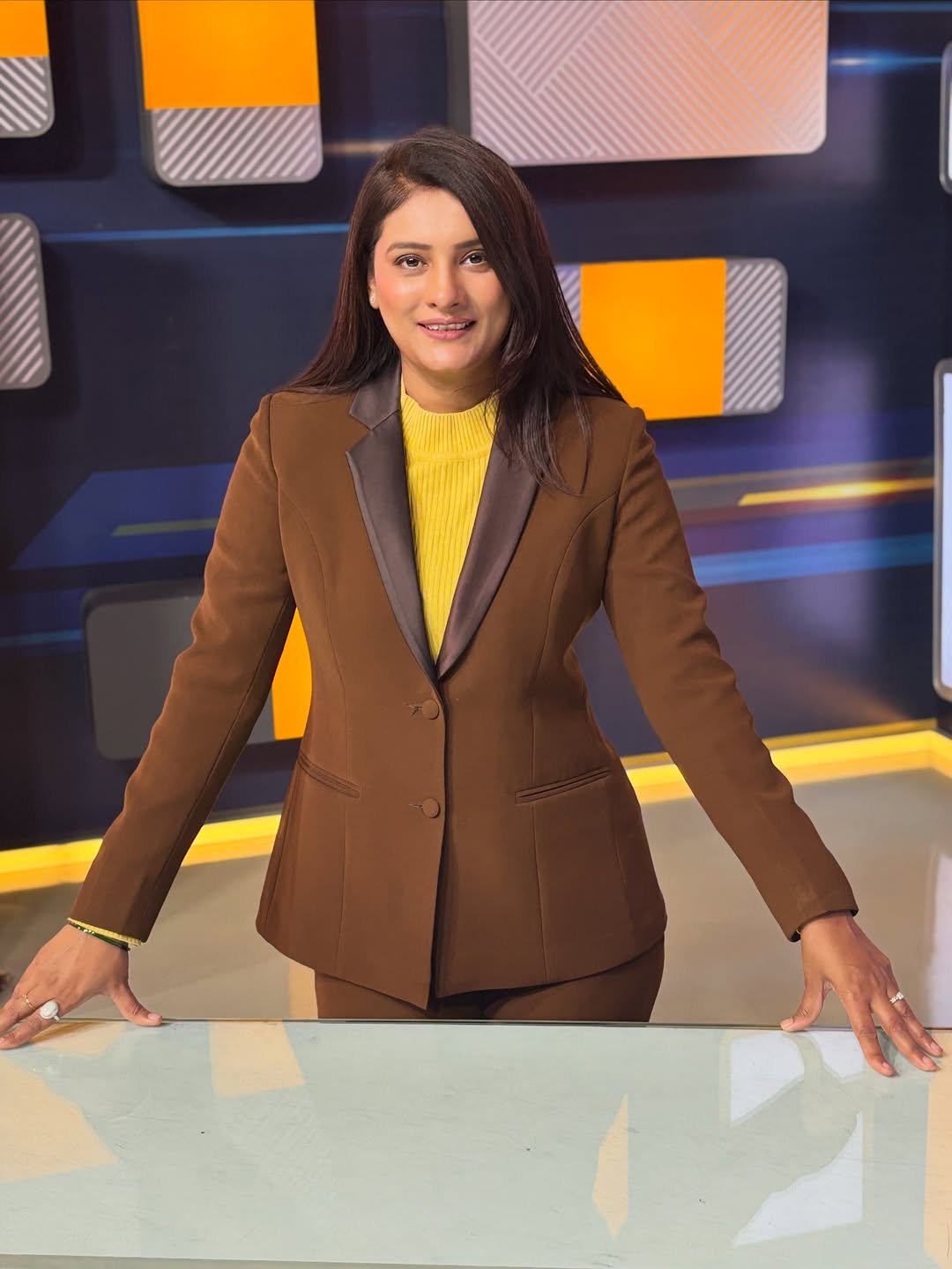 Photo by Romita Tiwari on December 25, 2025. May be an image of television, blazer, suit, newsroom, office and text.