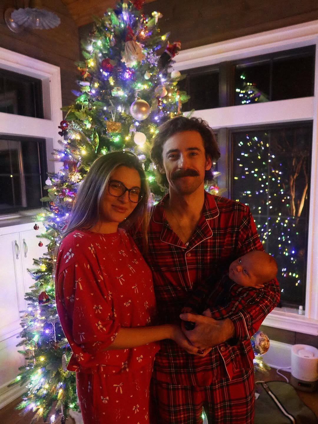 Photo shared by Ryan Blaney on December 25, 2025 tagging @giannatulio. May be an image of christmas tree, flannel, bath robe, tinsel and text.