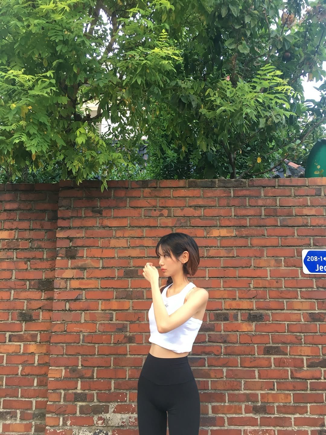 Photo shared by 🪄💖✨ on September 11, 2025 tagging @lululemonkr, @alo, and @aloseoul. May be an image of 1 person, activewear, tanktop, sportswear, tights, brick wall and text.