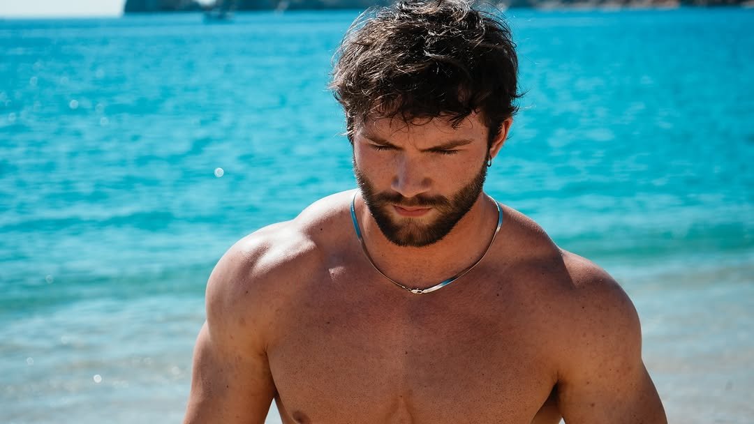 Photo by Sean on September 30, 2025. May be an image of one or more people, beard, biceps, people bodybuilding, beach and text.